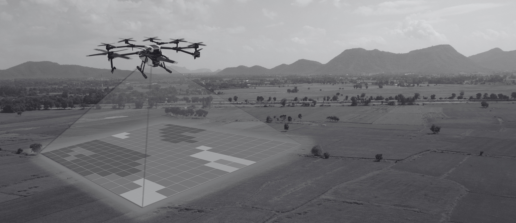 a black and white image of a drone flying over a field