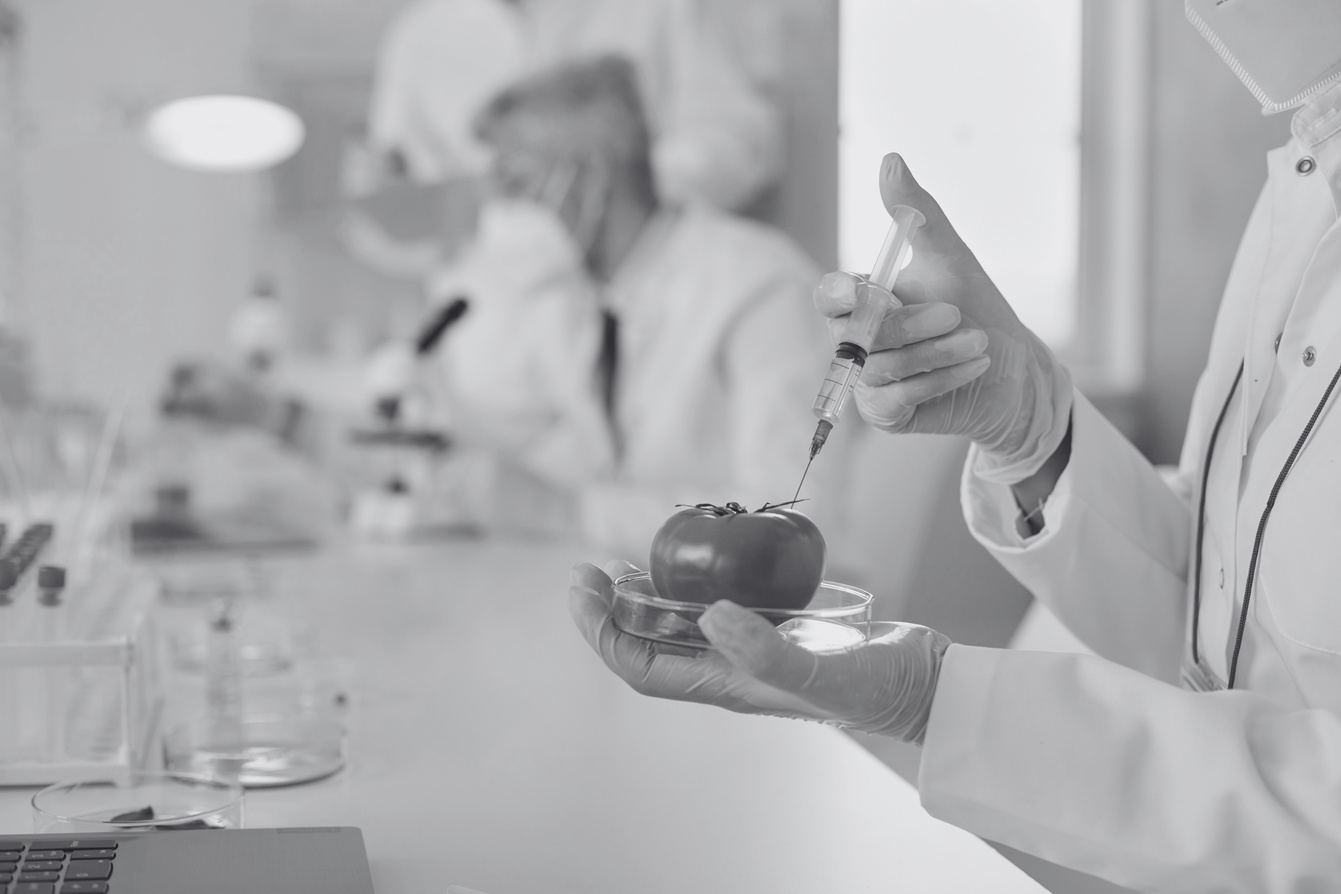 a black and white photo of a person in a lab coat holding an apple